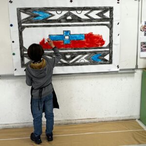 Enfant peignant une grande fresque collective pendant un atelier créatif à Fontainebleau